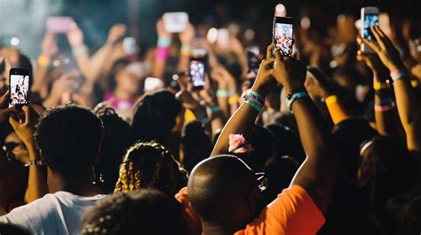 A crowd points their phone cameras in the same direction